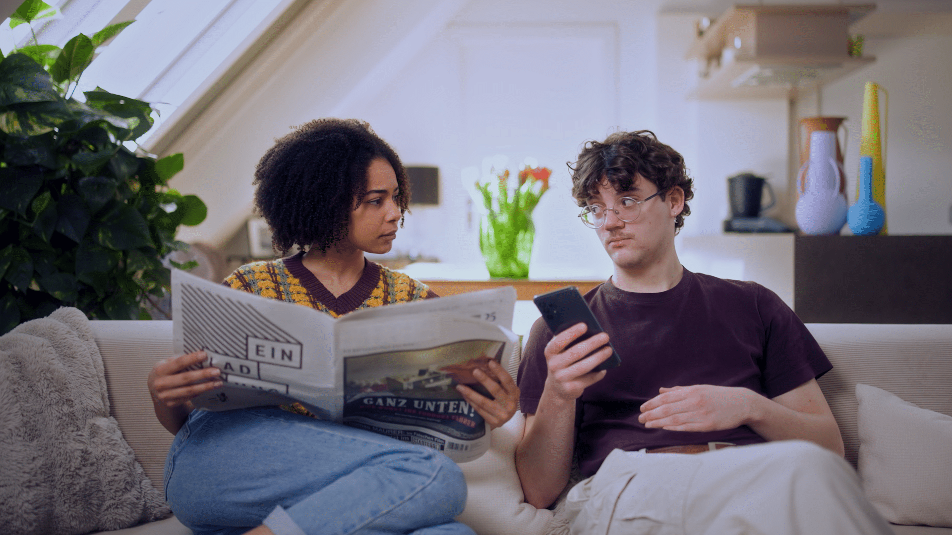 Zwei Personen sitzen auf der Couch bei den Dreharbeiten für ein Werbevideo.